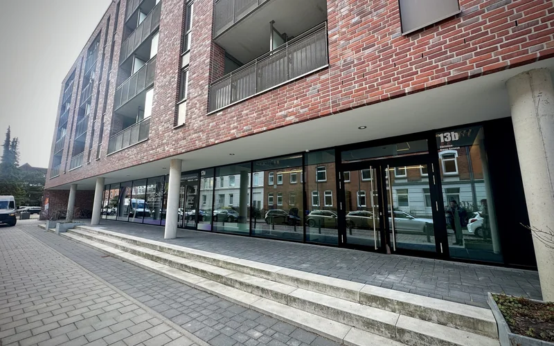 Backsteingebäude Christian-Kruse-Straße 13b in Kiel-Ravensberg mit den Schaufenstern des Büros im Erdgeschoss